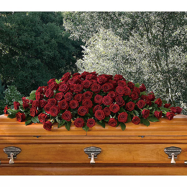 Wooden casket with a large arrangement of red roses